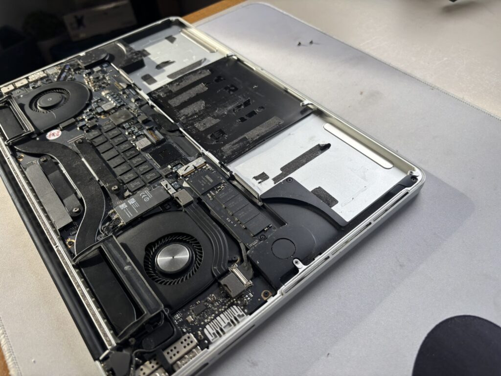Intérieur d'un MacBook Pro avec ventilateurs et batterie, en réparation
